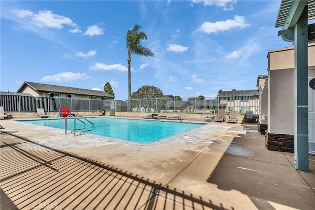 pool with a patio area and fence