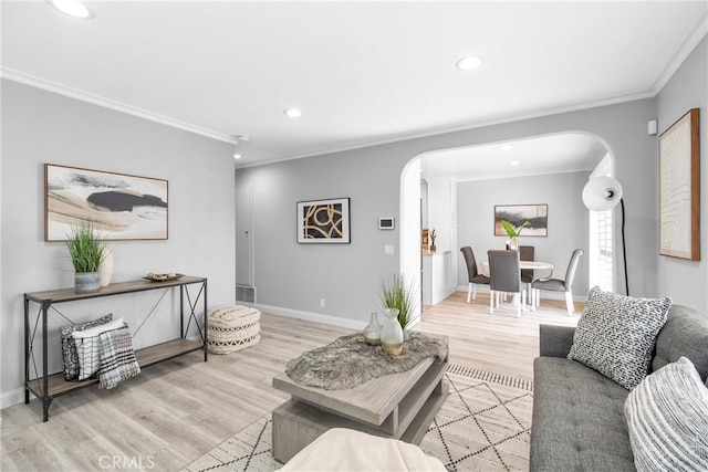 living area with recessed lighting, baseboards, arched walkways, and light wood-type flooring