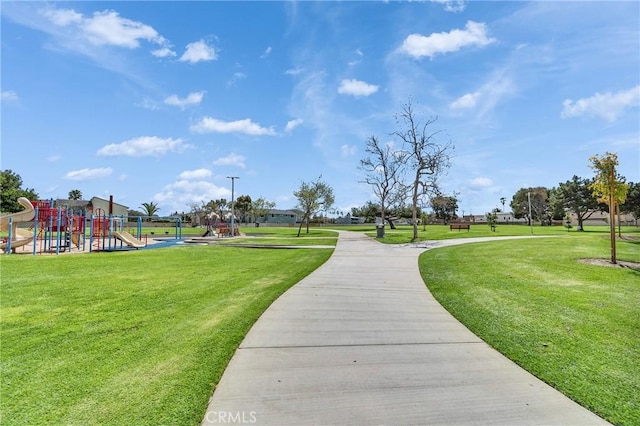 view of home's community featuring a yard and playground community