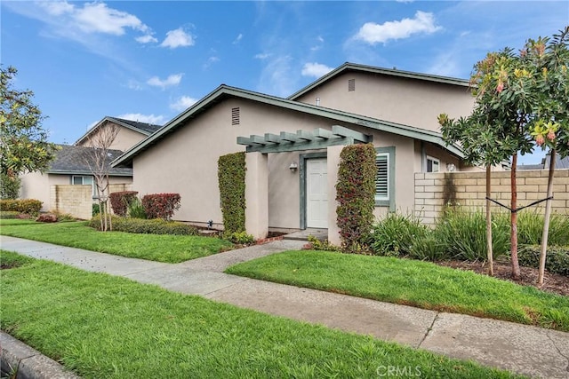 view of front of home featuring a front yard, fence, and stucco siding