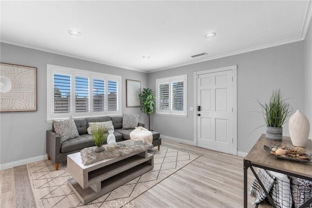 living room featuring crown molding, visible vents, baseboards, and light wood finished floors