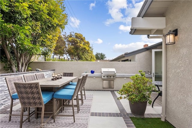 view of patio featuring grilling area, outdoor dining area, and fence