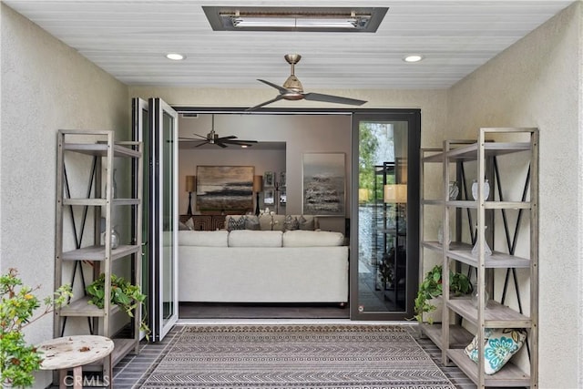 doorway to property featuring stucco siding and a ceiling fan