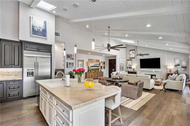 kitchen with a ceiling fan, dark wood-style flooring, built in refrigerator, and a sink