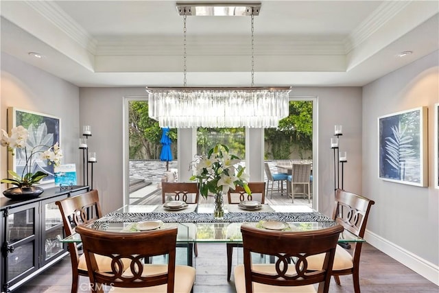 dining space with a wealth of natural light, a notable chandelier, and a raised ceiling