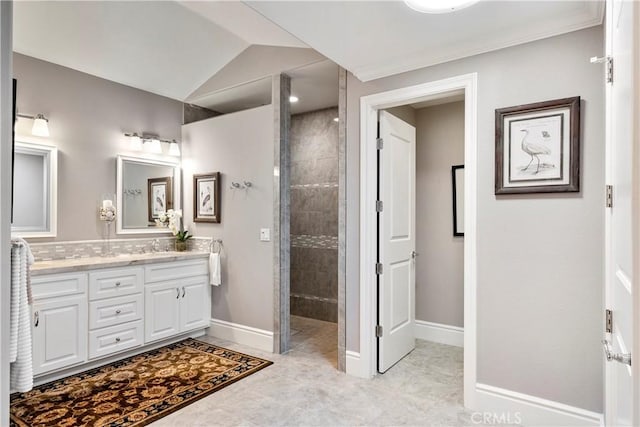 bathroom featuring vanity, a walk in shower, and baseboards