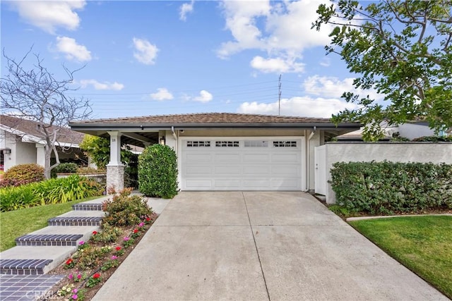 view of front facade with a garage, concrete driveway, and stucco siding