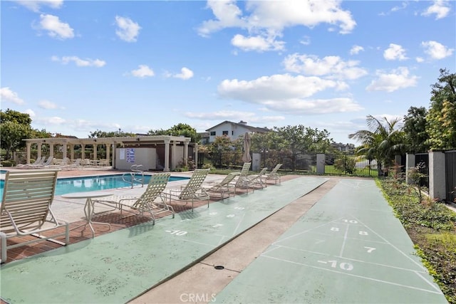 community pool featuring a patio area, shuffleboard, and fence