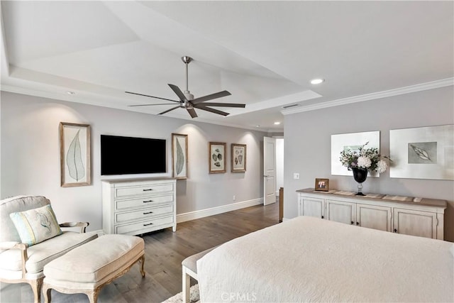 bedroom with dark wood finished floors, a tray ceiling, recessed lighting, and ornamental molding