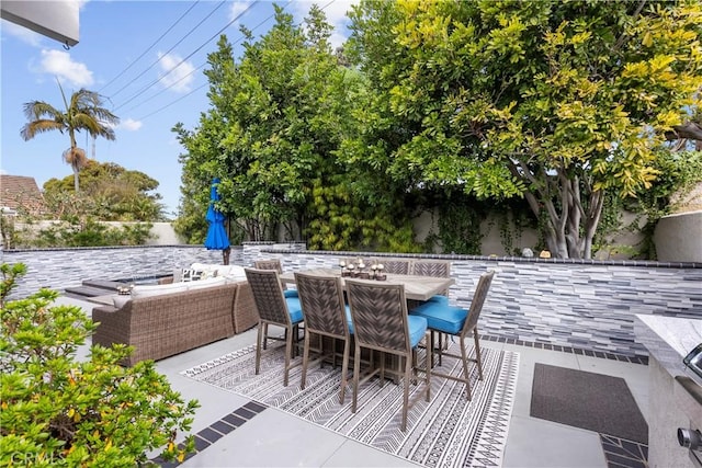 view of patio with outdoor dining area and fence