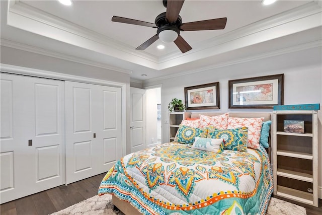 bedroom featuring crown molding, dark wood finished floors, recessed lighting, a closet, and a raised ceiling