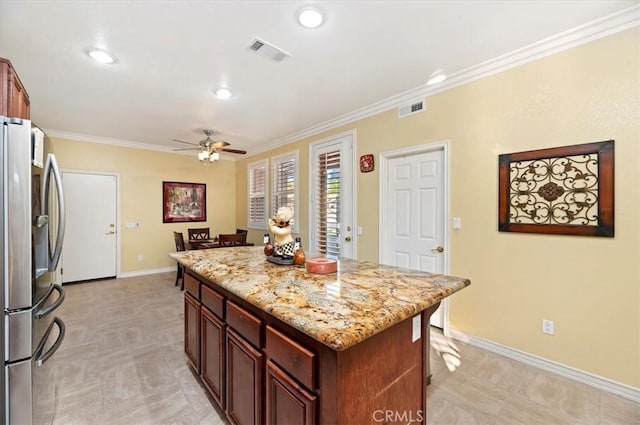 kitchen with visible vents, ceiling fan, ornamental molding, and freestanding refrigerator