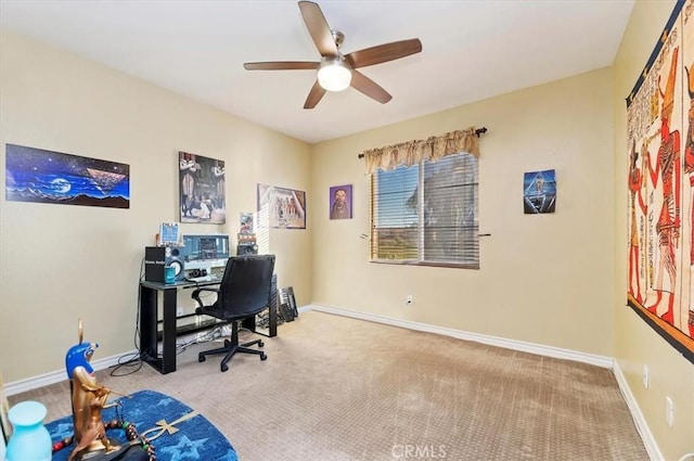 carpeted home office with a ceiling fan and baseboards