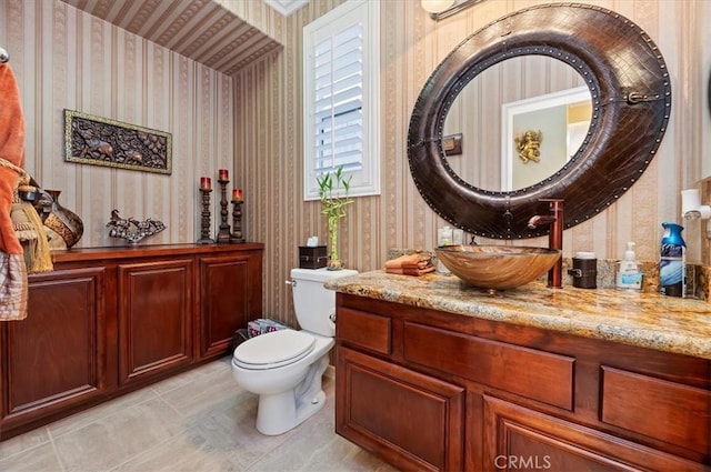 bathroom featuring wallpapered walls, toilet, and vanity