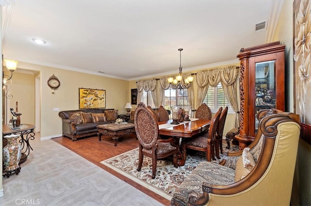 dining room with visible vents, baseboards, a notable chandelier, and ornamental molding