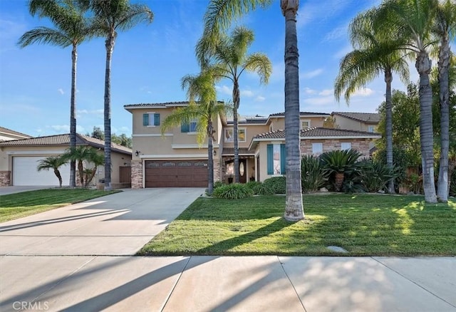 mediterranean / spanish-style home with stone siding, stucco siding, driveway, and a front lawn