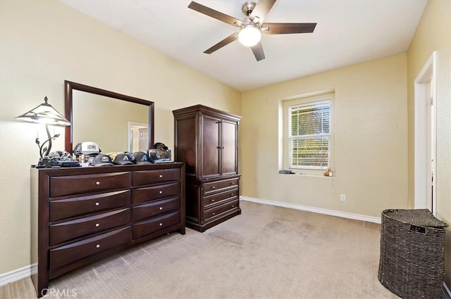 bedroom with light colored carpet, a ceiling fan, and baseboards