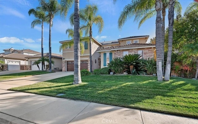 mediterranean / spanish home with stucco siding, stone siding, roof mounted solar panels, and a front yard