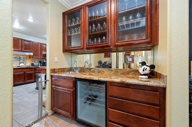 bar featuring beverage cooler, a sink, crown molding, light tile patterned floors, and wet bar