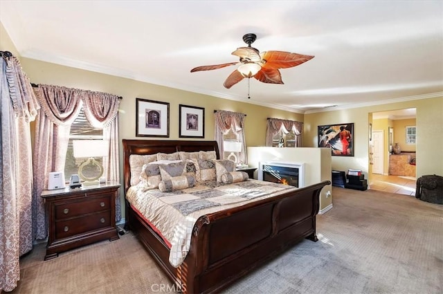 bedroom with light colored carpet, a lit fireplace, ceiling fan, and crown molding