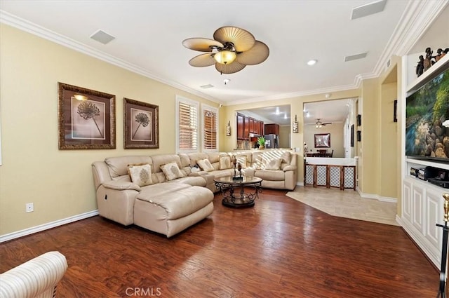 living room with visible vents, baseboards, ceiling fan, ornamental molding, and wood finished floors