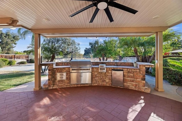 view of patio featuring area for grilling, an outdoor kitchen, a ceiling fan, and fence