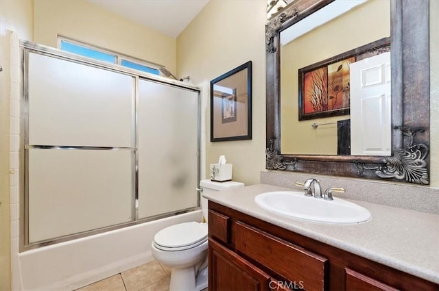 full bath featuring vanity, tile patterned floors, toilet, and combined bath / shower with glass door