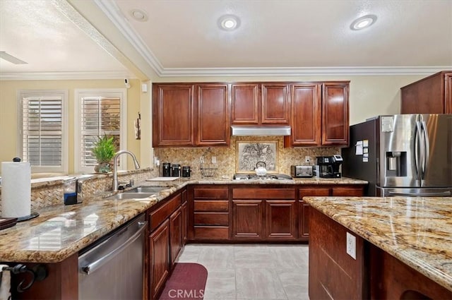 kitchen featuring light stone countertops, a sink, stainless steel appliances, under cabinet range hood, and tasteful backsplash