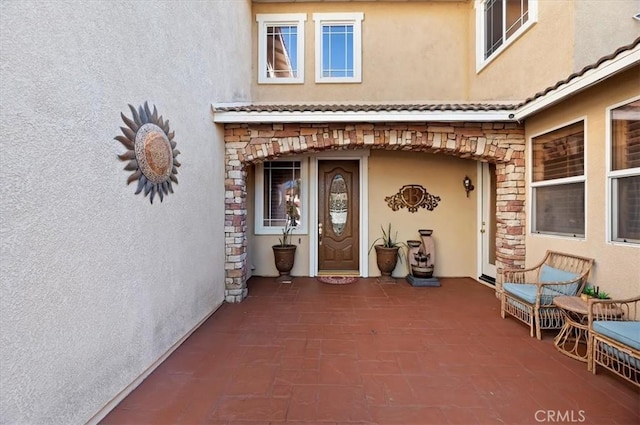 property entrance featuring stone siding and stucco siding