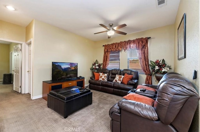 living room featuring visible vents, light carpet, baseboards, and a ceiling fan