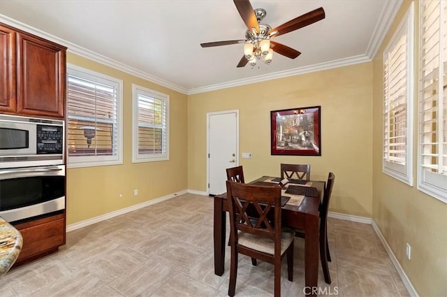 dining room featuring baseboards, ornamental molding, and a ceiling fan