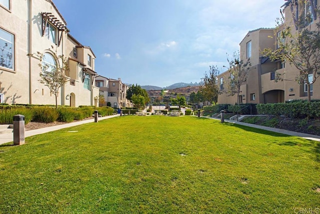 surrounding community featuring a yard, a residential view, and a mountain view