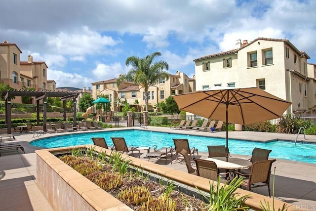 pool with a patio area, a residential view, and fence