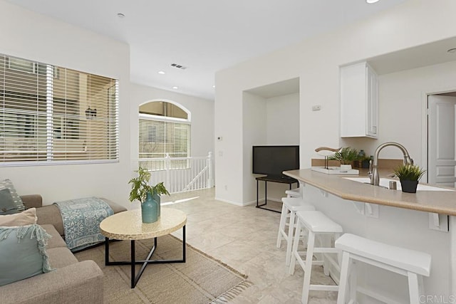 living area featuring recessed lighting, visible vents, and baseboards