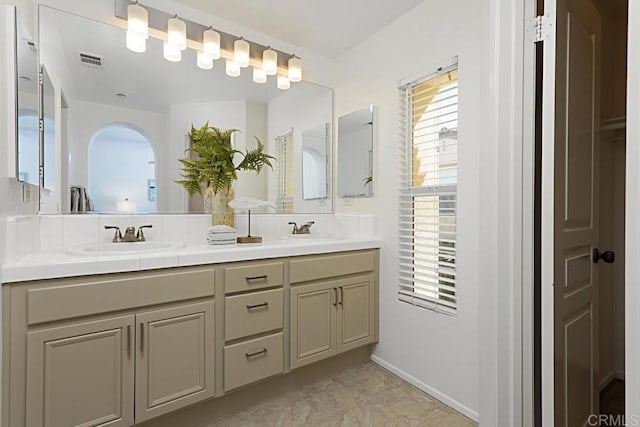 bathroom with a sink, visible vents, and double vanity