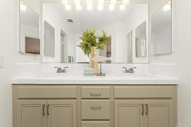 full bathroom with double vanity, visible vents, and a sink