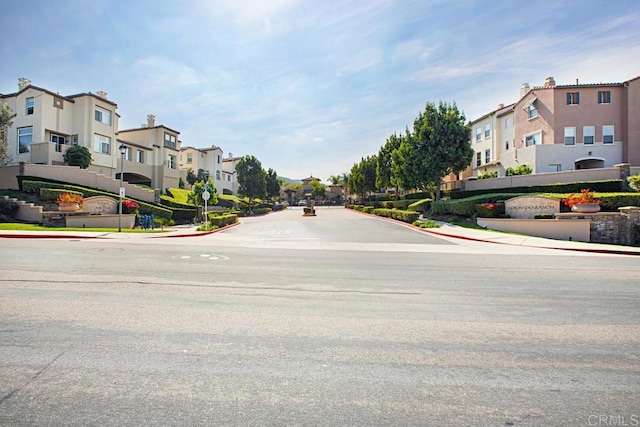 view of street with curbs, sidewalks, and a residential view