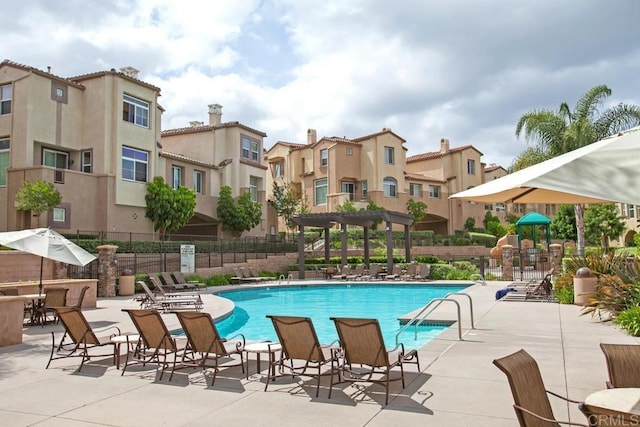 pool with a patio area, a residential view, and fence