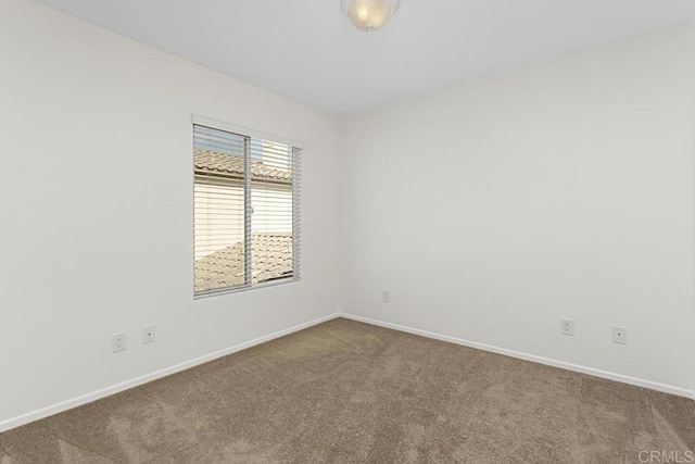 empty room featuring baseboards and carpet floors