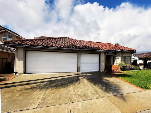 mediterranean / spanish house with stucco siding, a tiled roof, an attached garage, and driveway