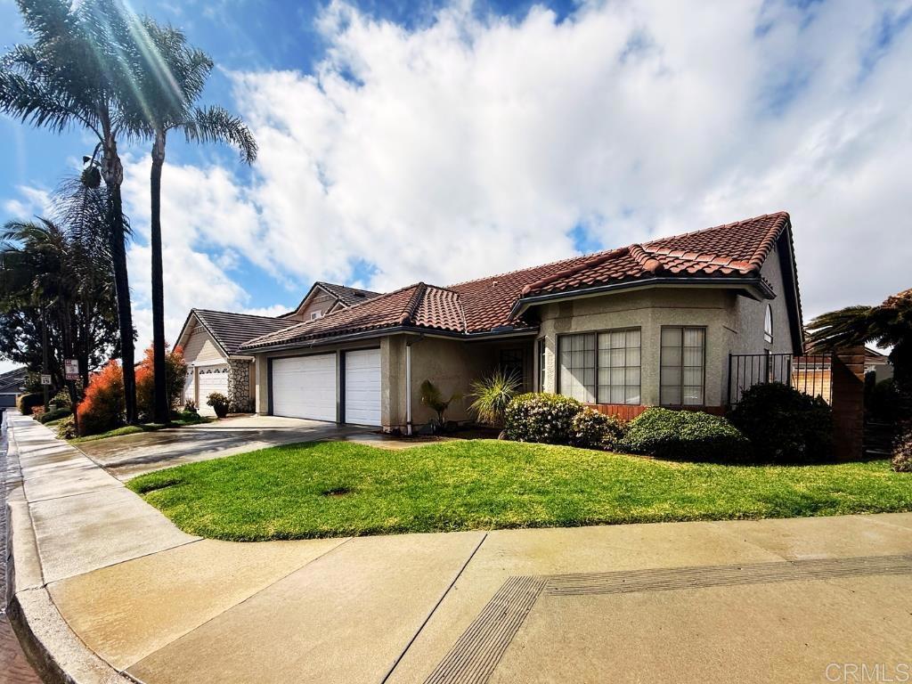 mediterranean / spanish-style home featuring a front yard, stucco siding, concrete driveway, a garage, and a tile roof