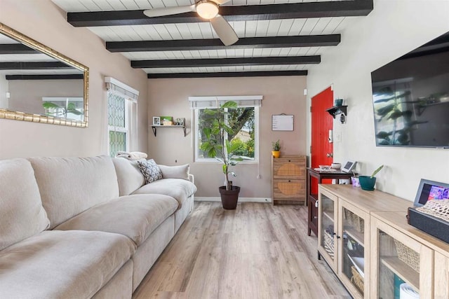 living room featuring beam ceiling, light wood finished floors, baseboards, and a ceiling fan