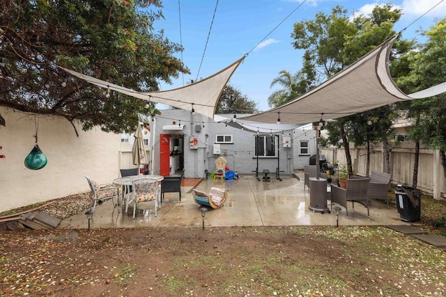 rear view of house featuring a patio area and fence