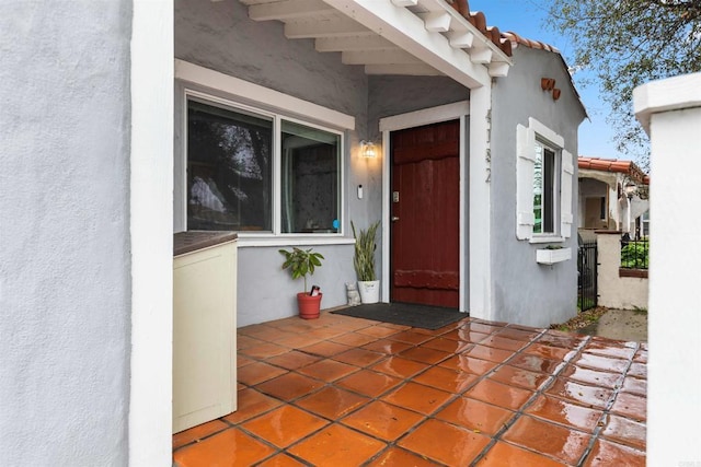 property entrance featuring stucco siding and a tiled roof