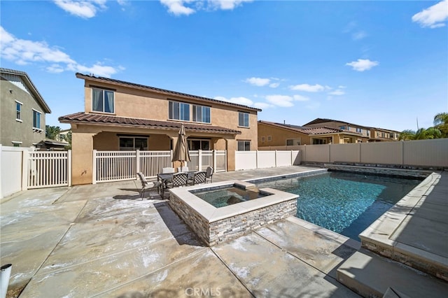 view of pool with a patio, a fenced backyard, and a pool with connected hot tub