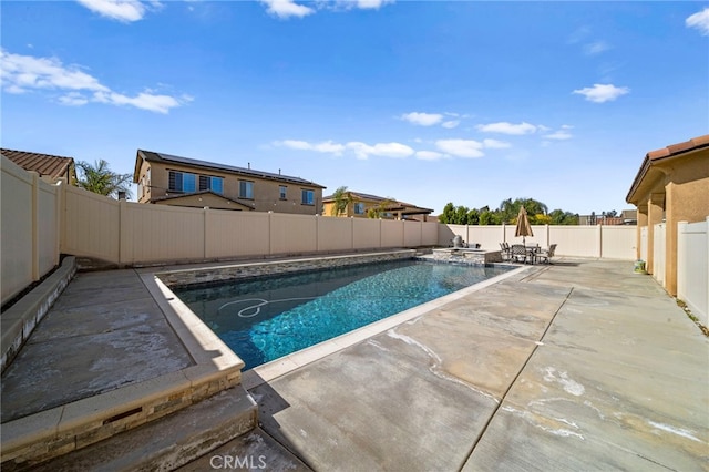 view of swimming pool featuring a patio area, a pool with connected hot tub, and a fenced backyard