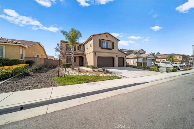 view of front of property featuring fence, a tile roof, stucco siding, driveway, and an attached garage