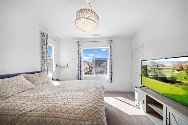 bedroom featuring visible vents, carpet floors, and a chandelier