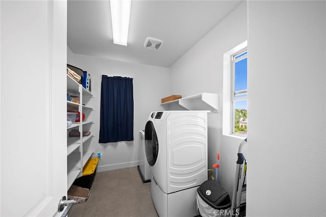 washroom with laundry area, baseboards, and washing machine and clothes dryer