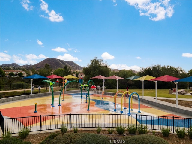 community playground featuring fence and a mountain view